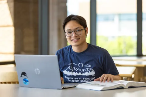 international student working on their computer in the university center